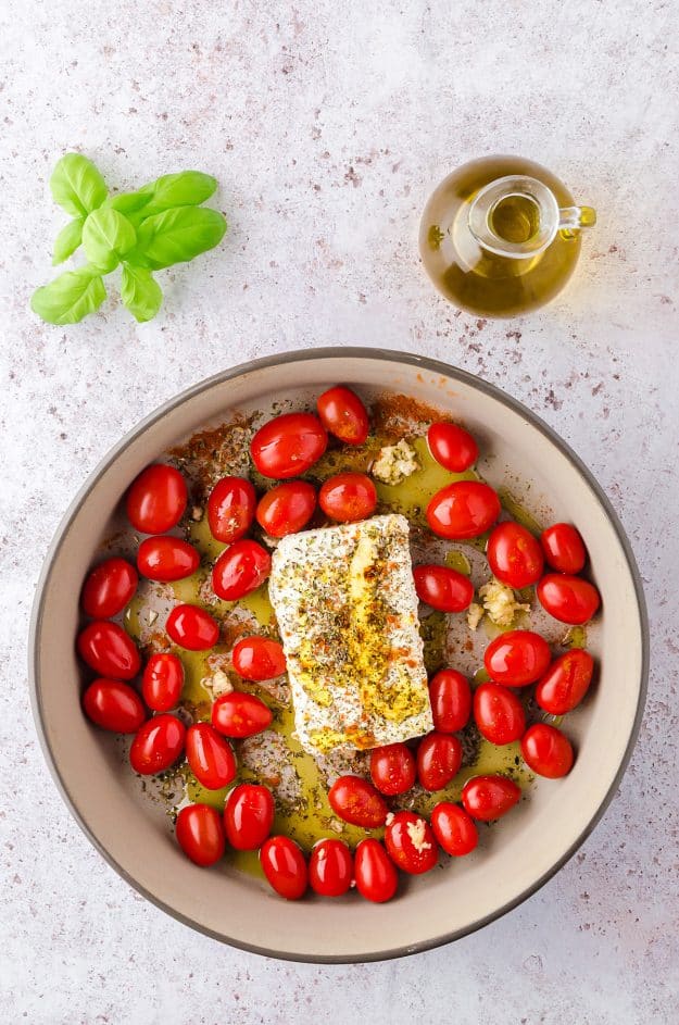 cherry tomatoes and feta cheese in baking dish.