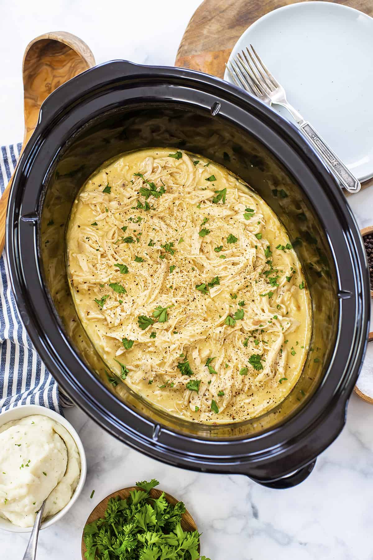 Shredded chicken and gravy in crockpot.