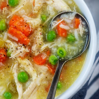 chicken rice soup in white bowl with vintage spoon.