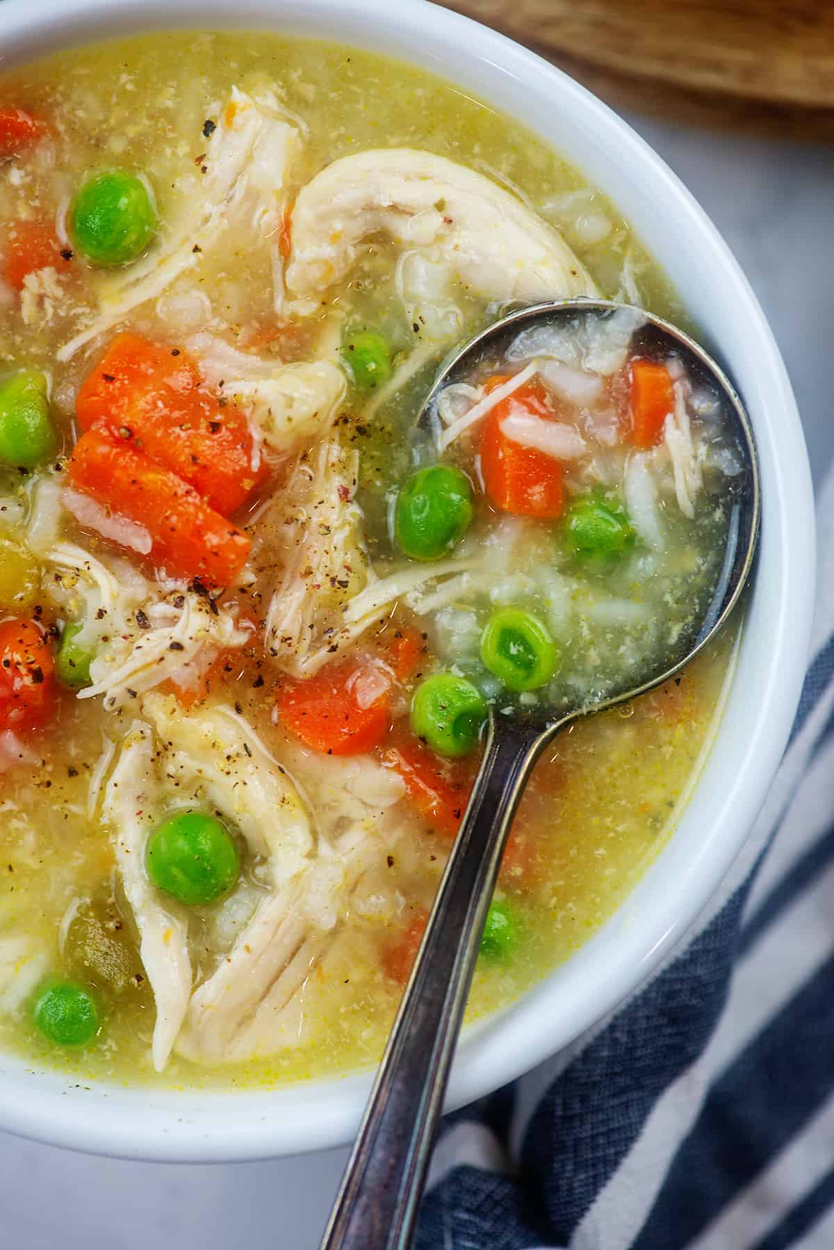 chicken rice soup in white bowl with vintage spoon.