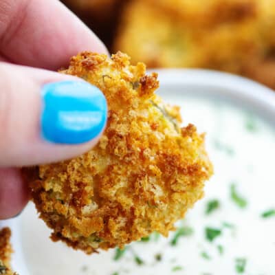 crispy air fryer fried pickles over a bowl of ranch dip.