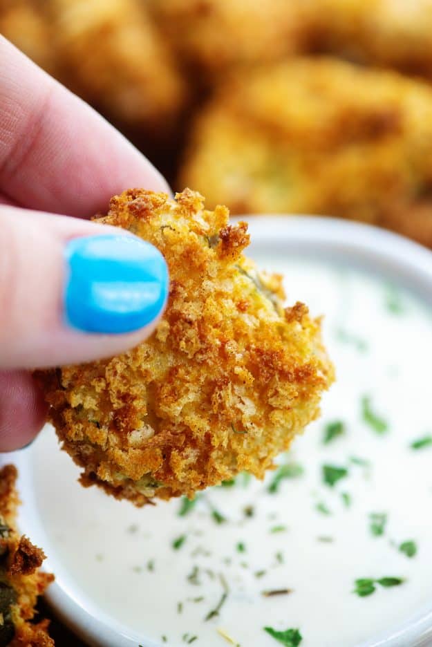 crispy air fryer fried pickles over a bowl of ranch dip.