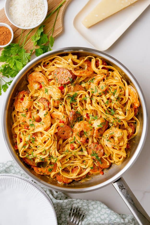 skillet filled with pasta, shrimp, and sausage.