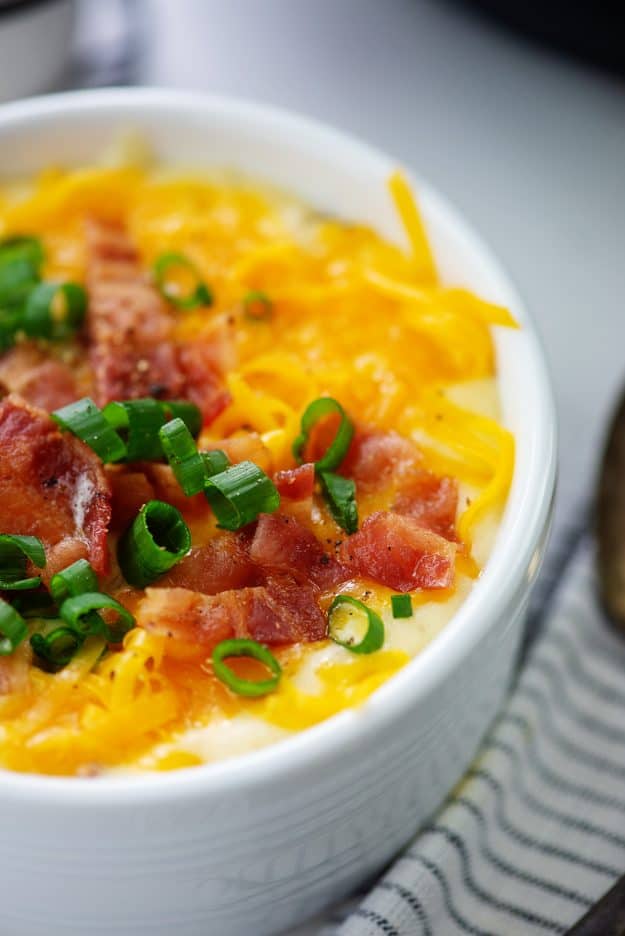 white bowl full of cheesy potato soup.