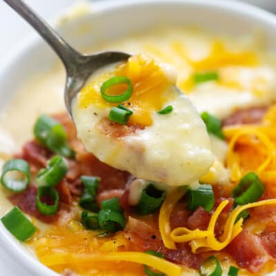 creamy Instant Pot potato soup on spoon over soup bowl.