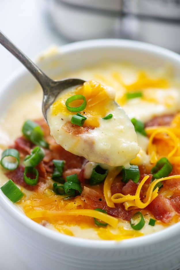 creamy Instant Pot potato soup on spoon over soup bowl.