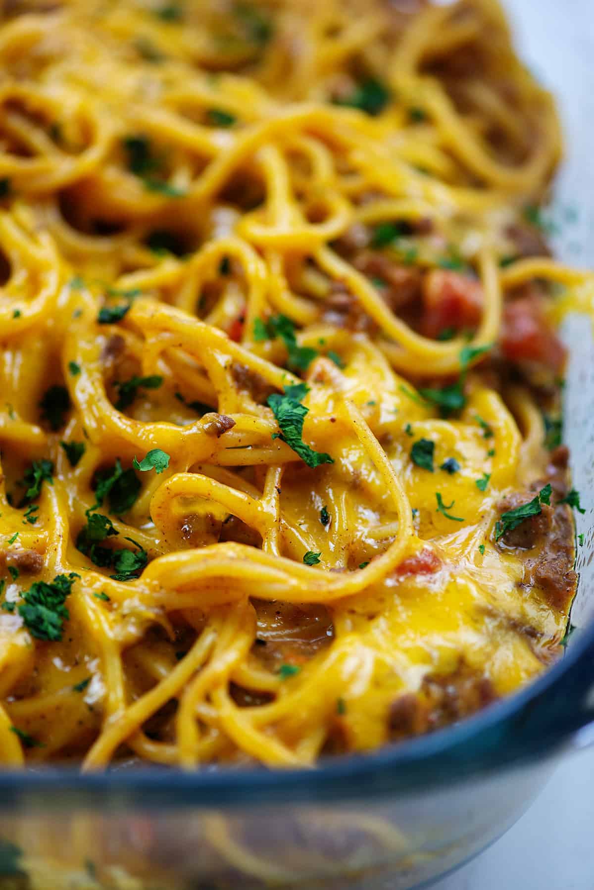cheesy taco spaghetti casserole in glass baking dish.