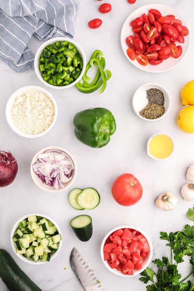 vegetables for salad on white countertop.