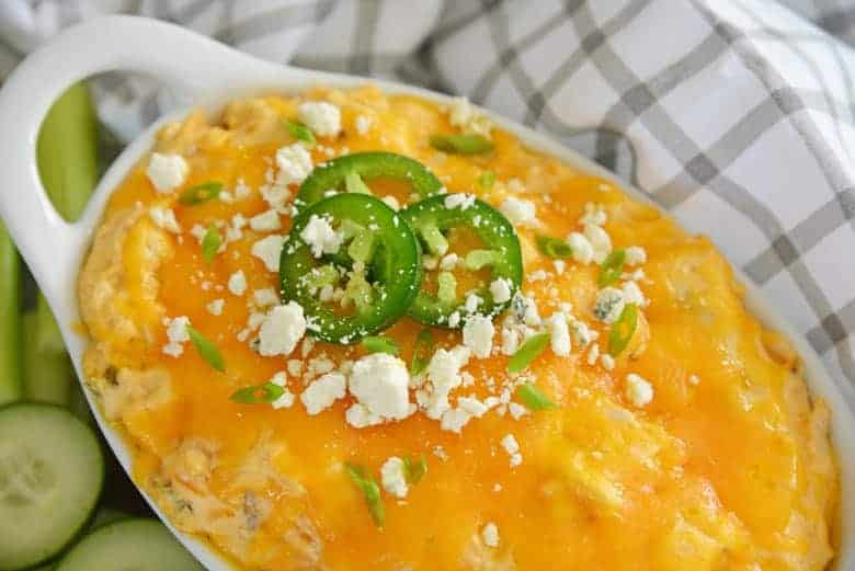 Close up view of buffalo chicken dip in a white serving dish.