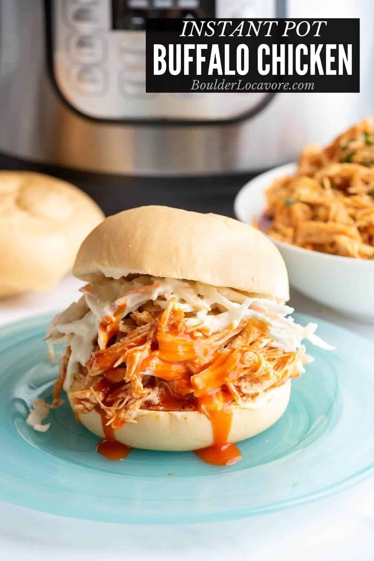 A buffalo chicken sandwich with coleslaw and buffalo sauce on a glass plate.