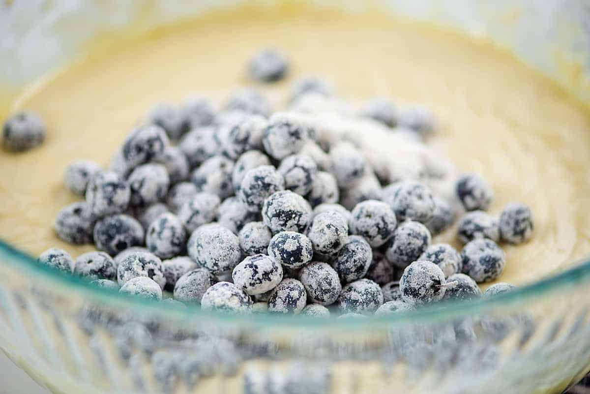 flour coated blueberries in glass mixing bowl.