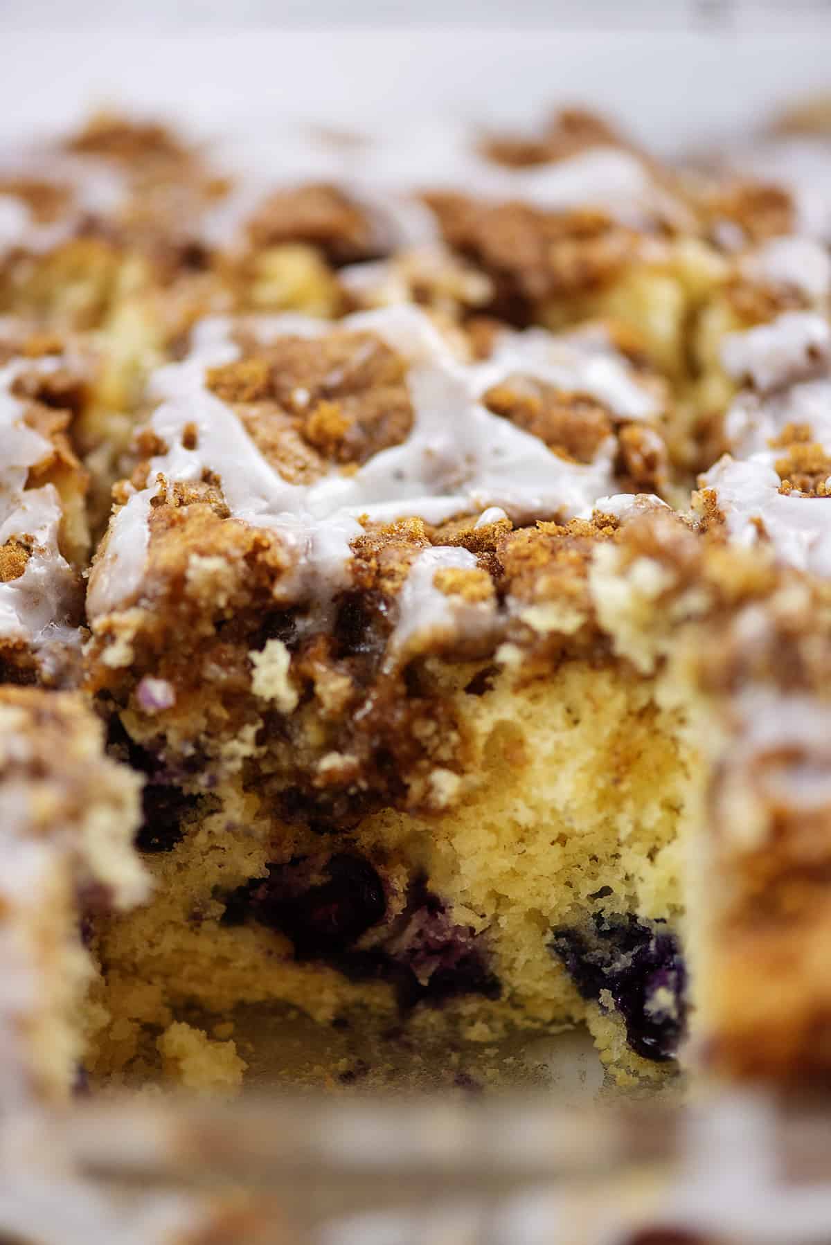 blueberry cinnamon roll breakfast cake with a slice taken out.
