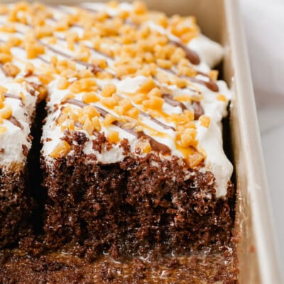chocolate cake with caramel and whipped topping in pan.