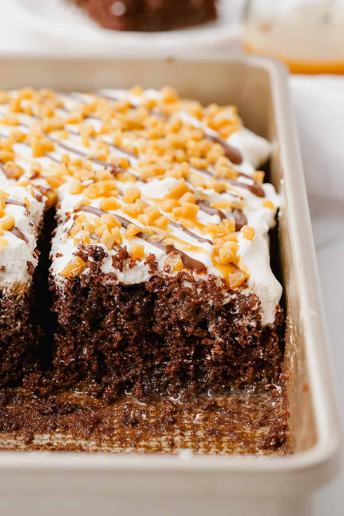 chocolate cake with caramel and whipped topping in pan.