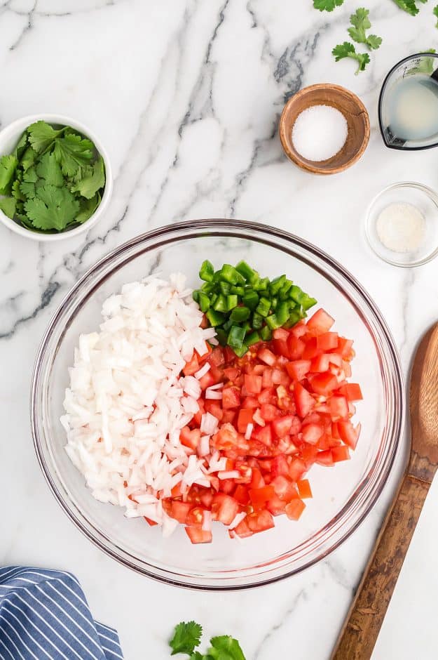 ingredients for salsa fresca in glass bowl.