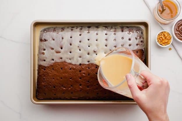 caramel sauce and sweetened condensed milk poured over a chocolate cake.