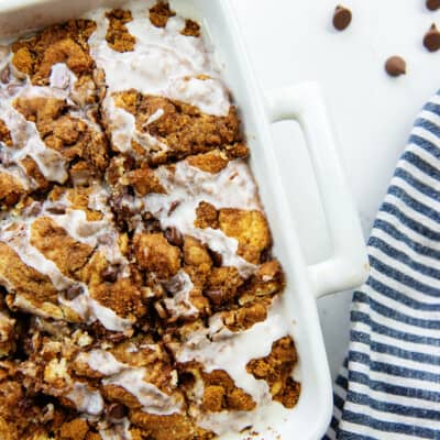 overhead shot of chocolate chip cinnamon roll cake in white dish.