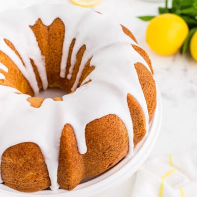 lemon bundt cake recipe on white cake stand.