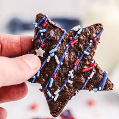 woman holding a star shaped brownie decorated for the Fourth of July.