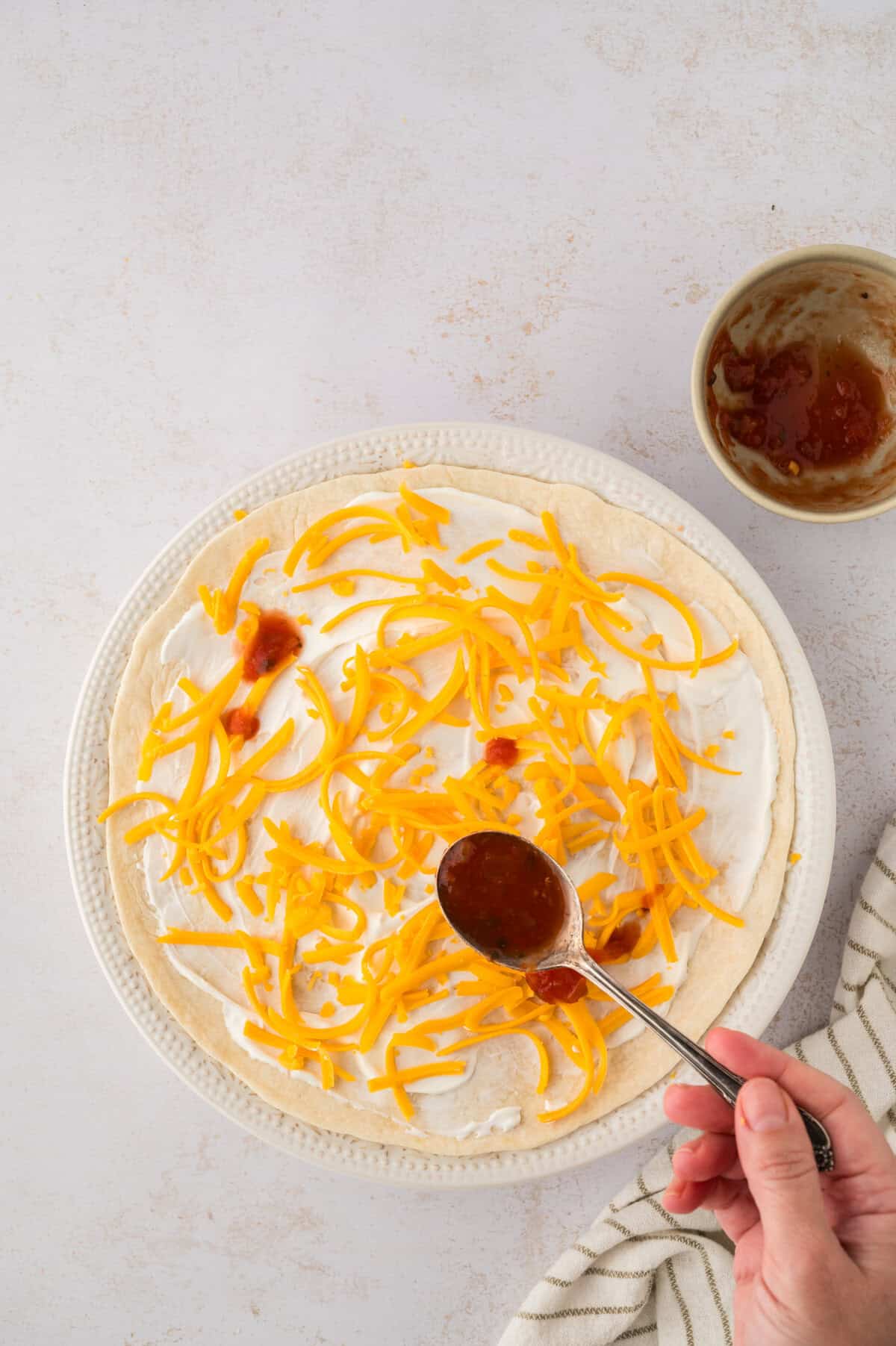 Salsa being drizzled over burrito casserole.