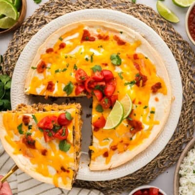 Slice of burrito casserole being removed from dish.