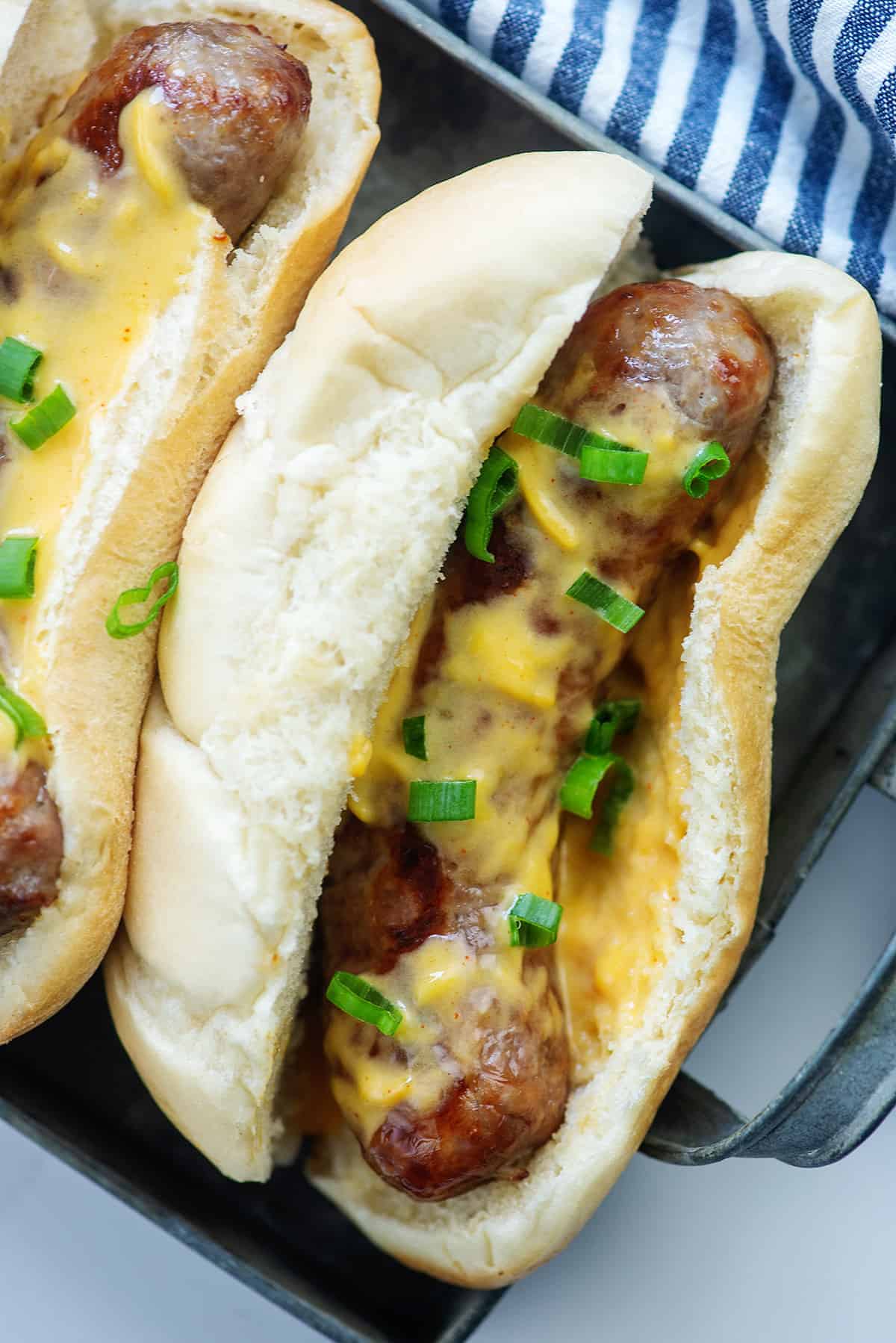 cheesy brats in bun on tray.