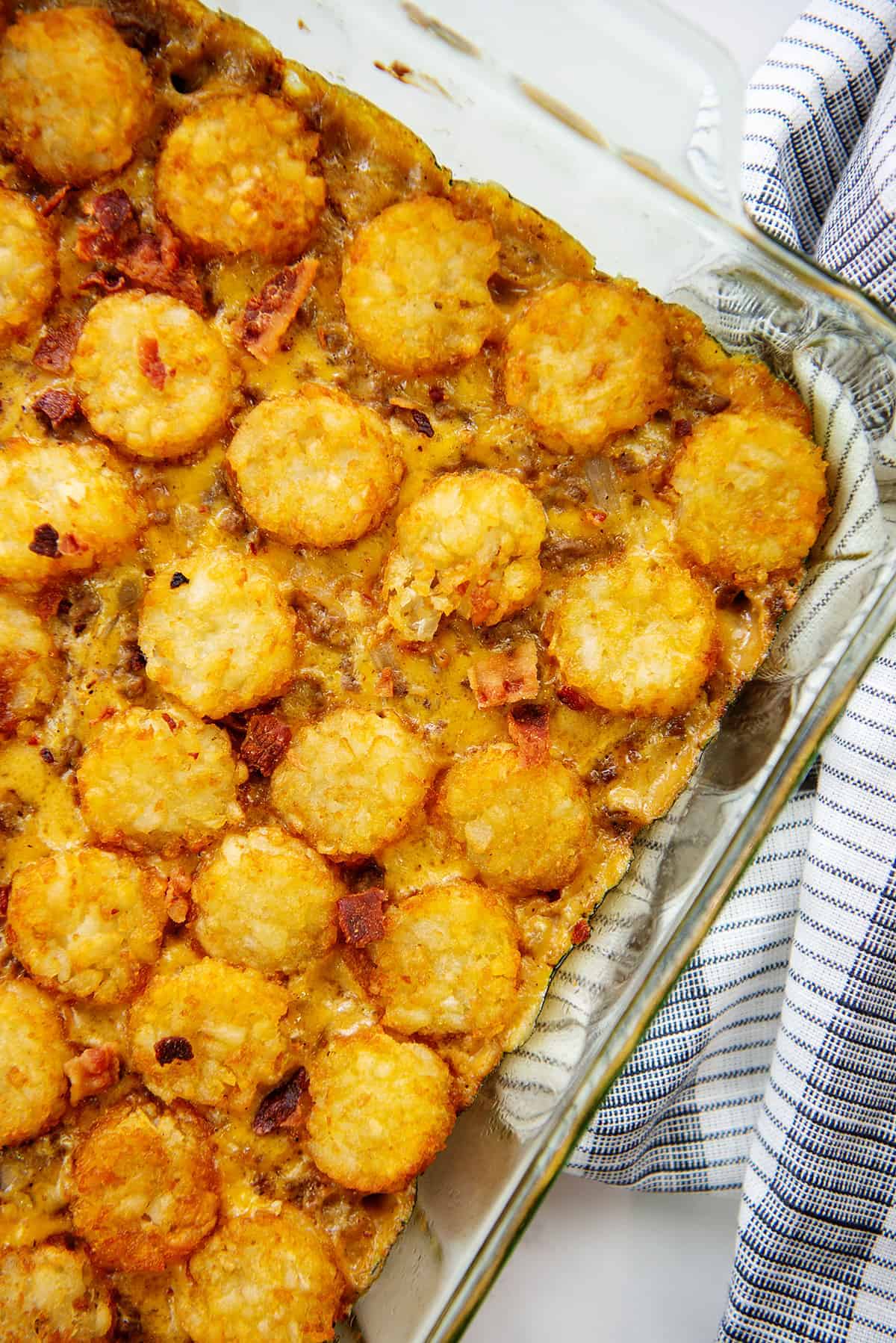 cheeseburger tater tot casserole in glass baking dish.