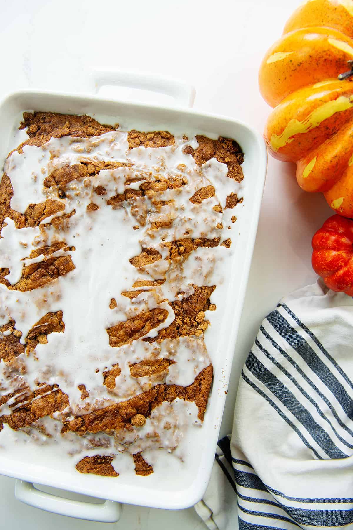 pumpkin cinnamon roll cake with glaze on top.