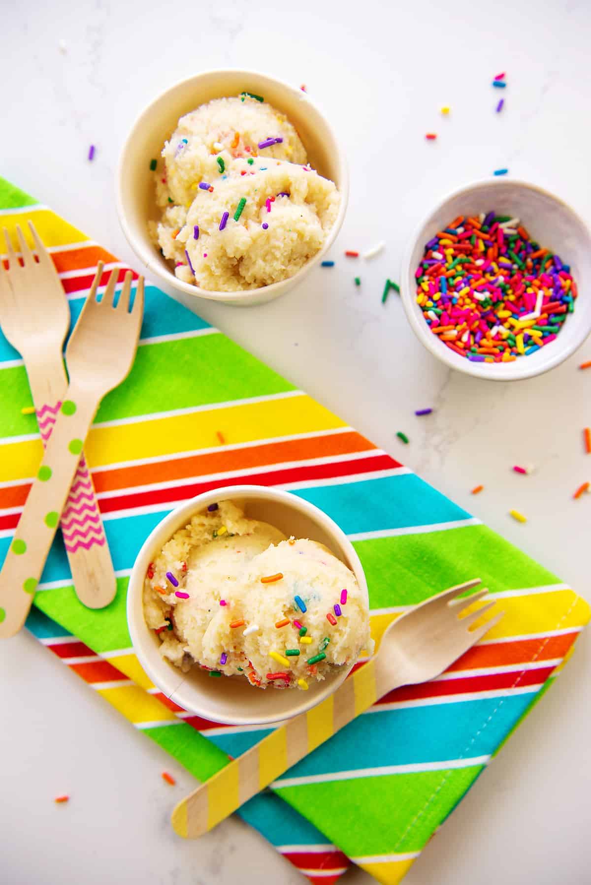 bowls of cookie dough on striped napkin.