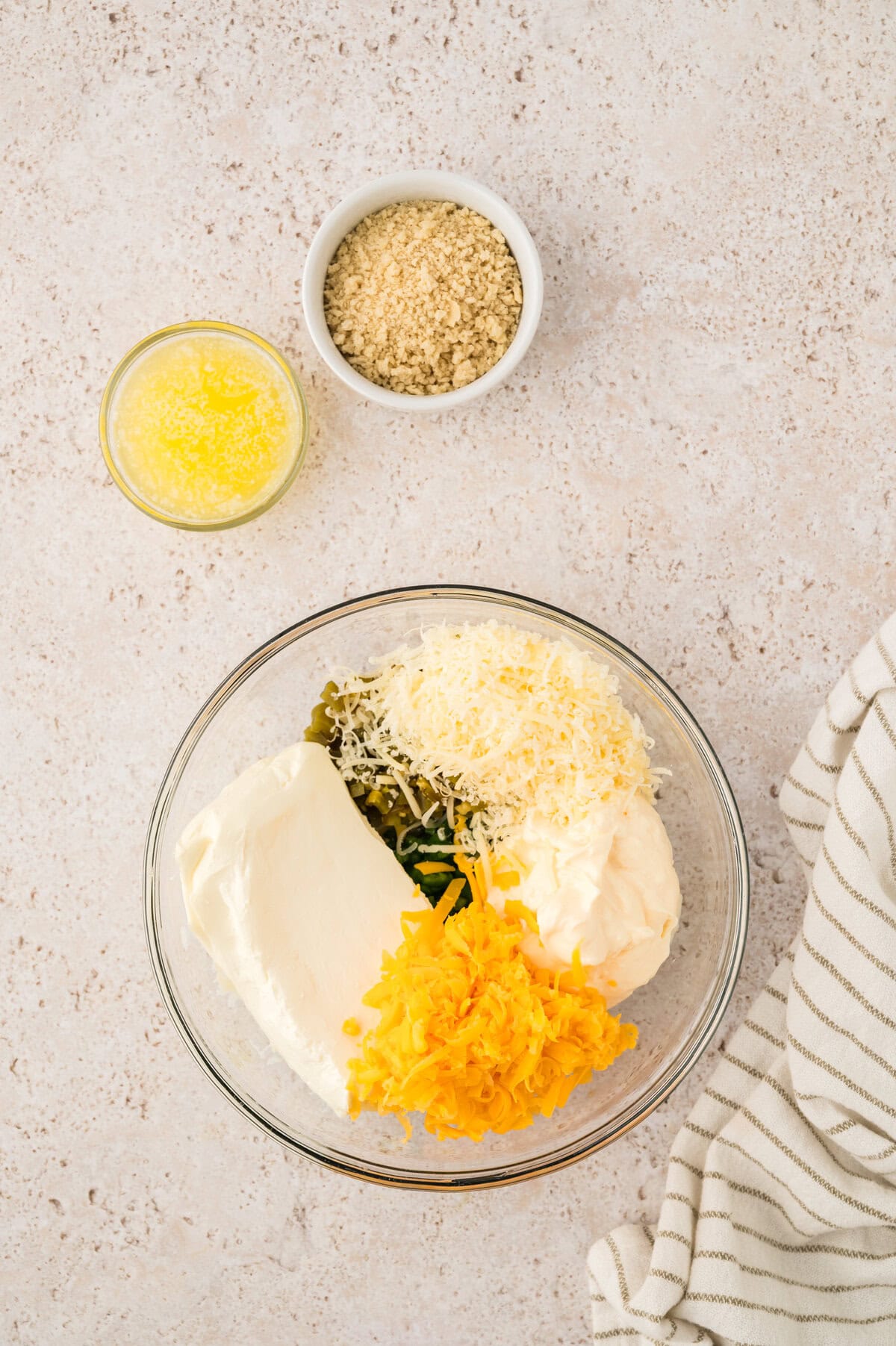 Ingredients for jalapeno cheese dip in glass mixing bowl.