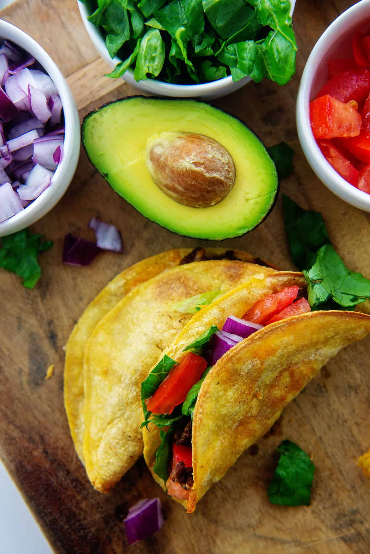 fried air fryer tacos on wooden board.