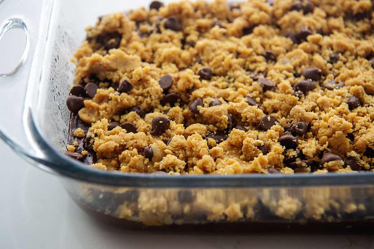 cookie dough on top of brownie batter in baking dish.