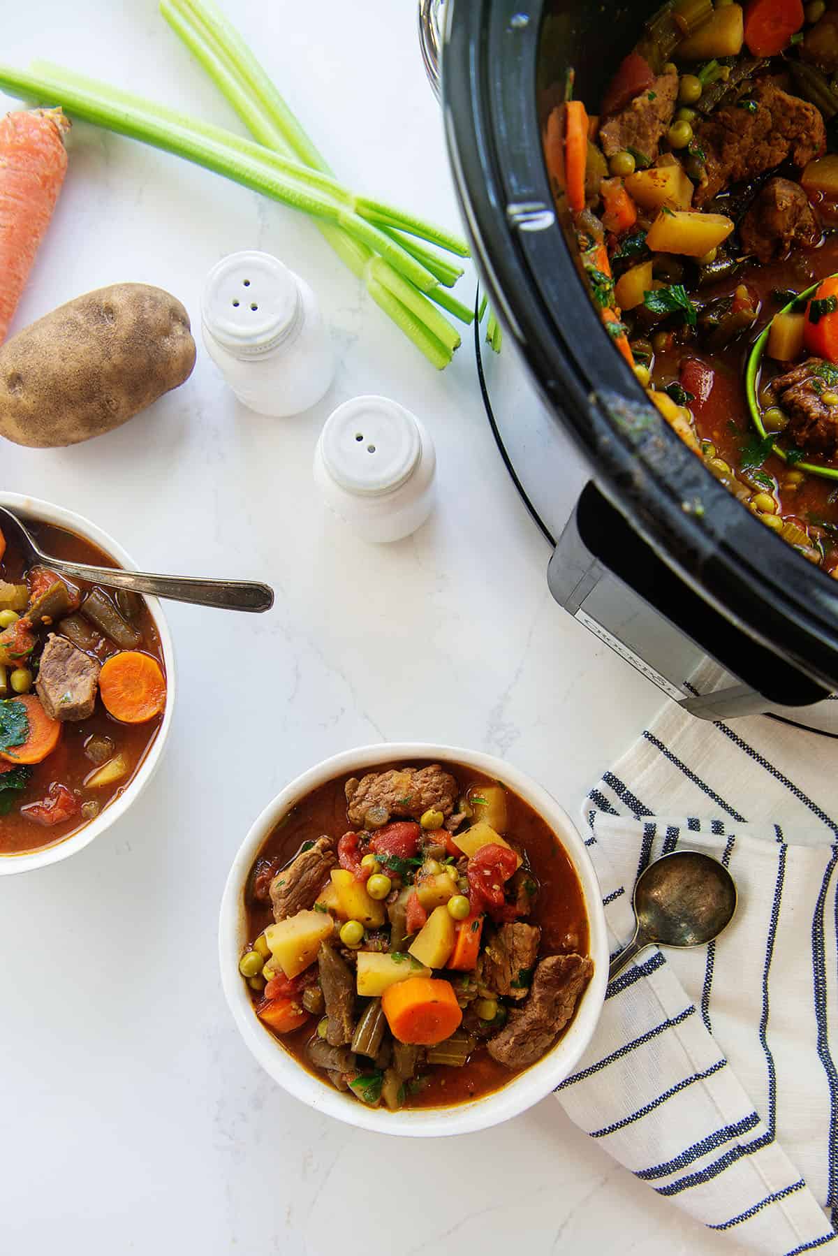 crockpot vegetable beef soup in white bowls.