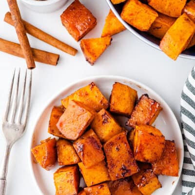 overhead view of honey cinnamon sweet potatoes on white plate.
