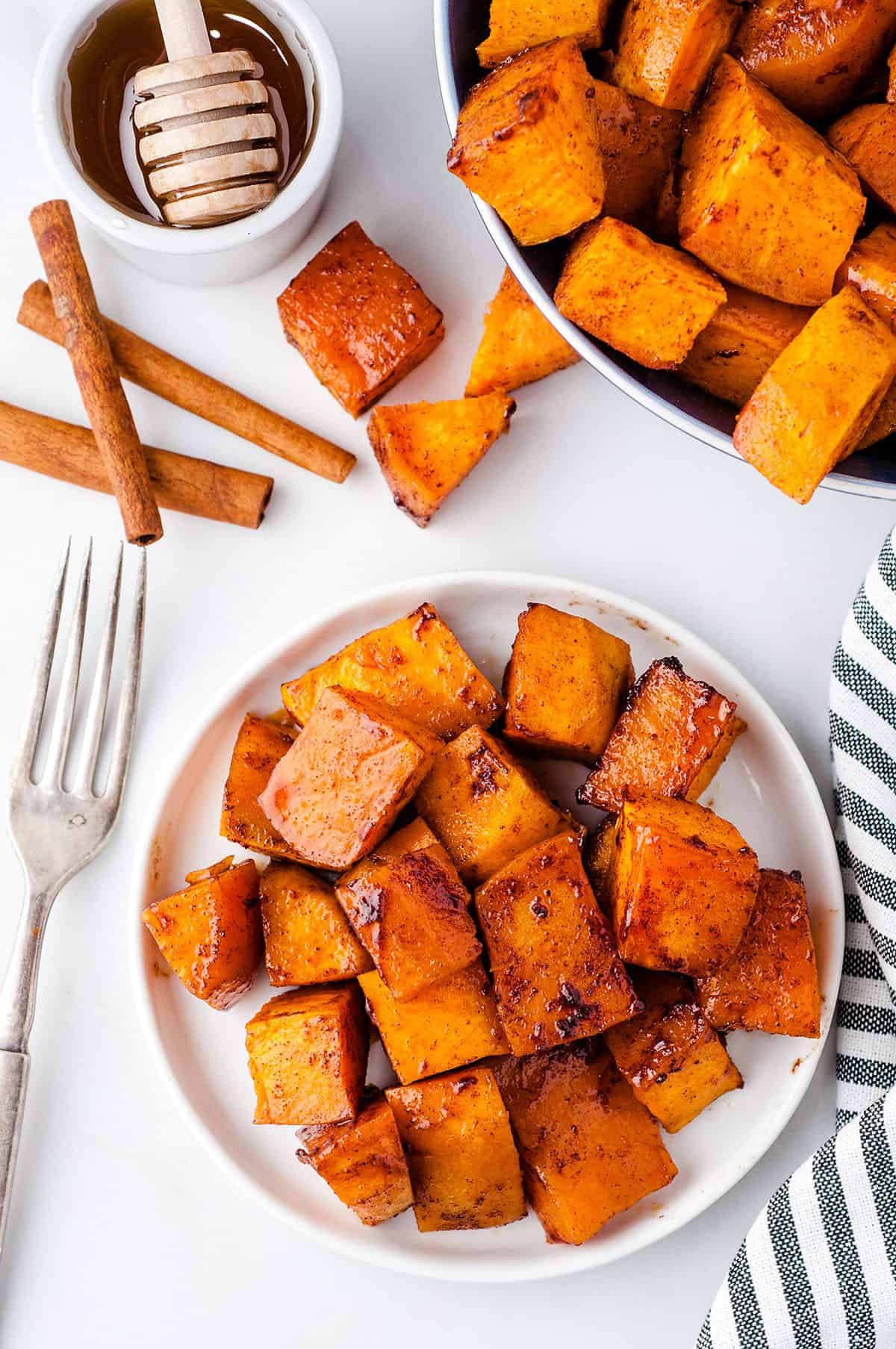 overhead view of honey cinnamon sweet potatoes on white plate.