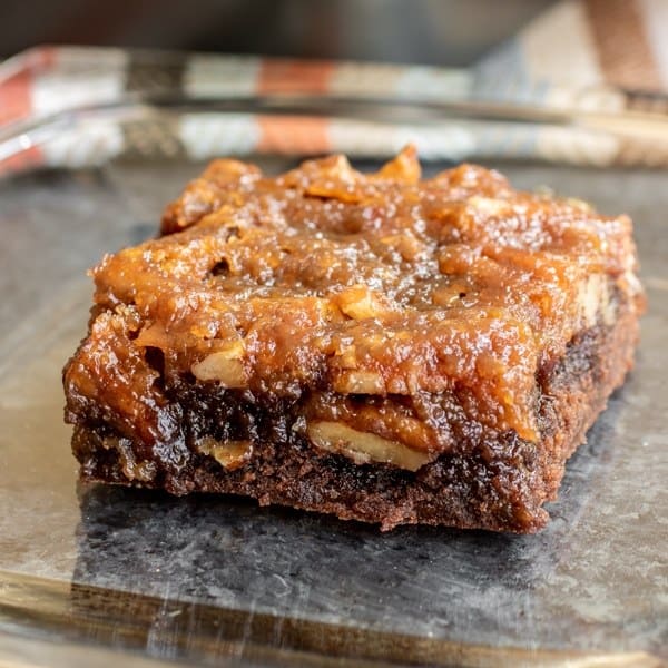 A close up view of a pecan pie brownie in a glass dish.