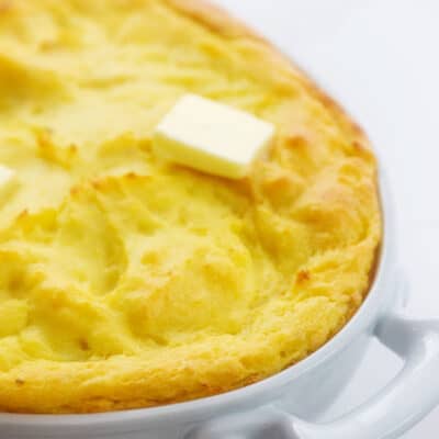 puffy baked potatoes in white dish.