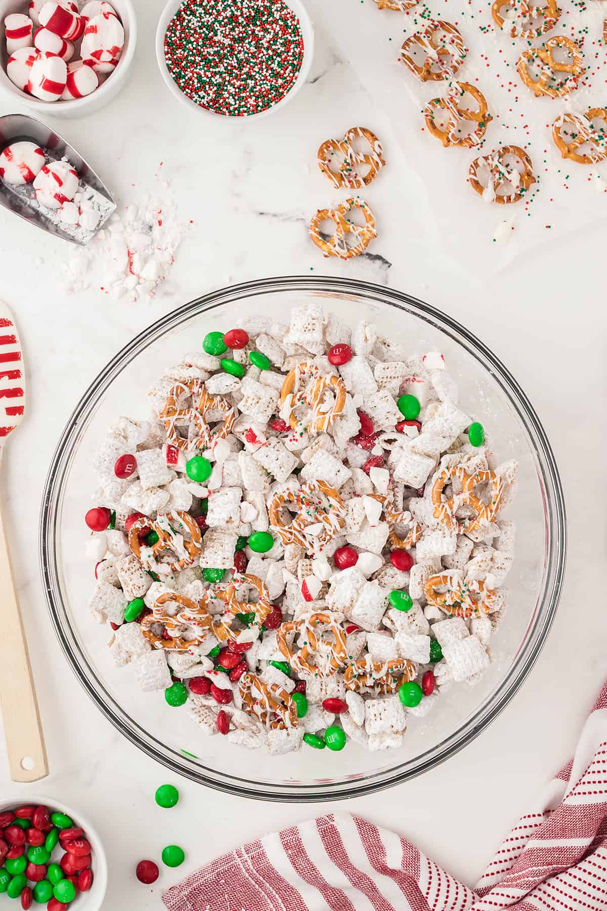 ingredients for holiday Chex mix in glass bowl.