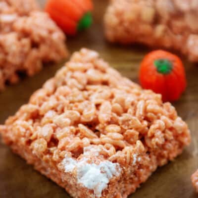 pumpkin spice rice krispies treats on wooden board.