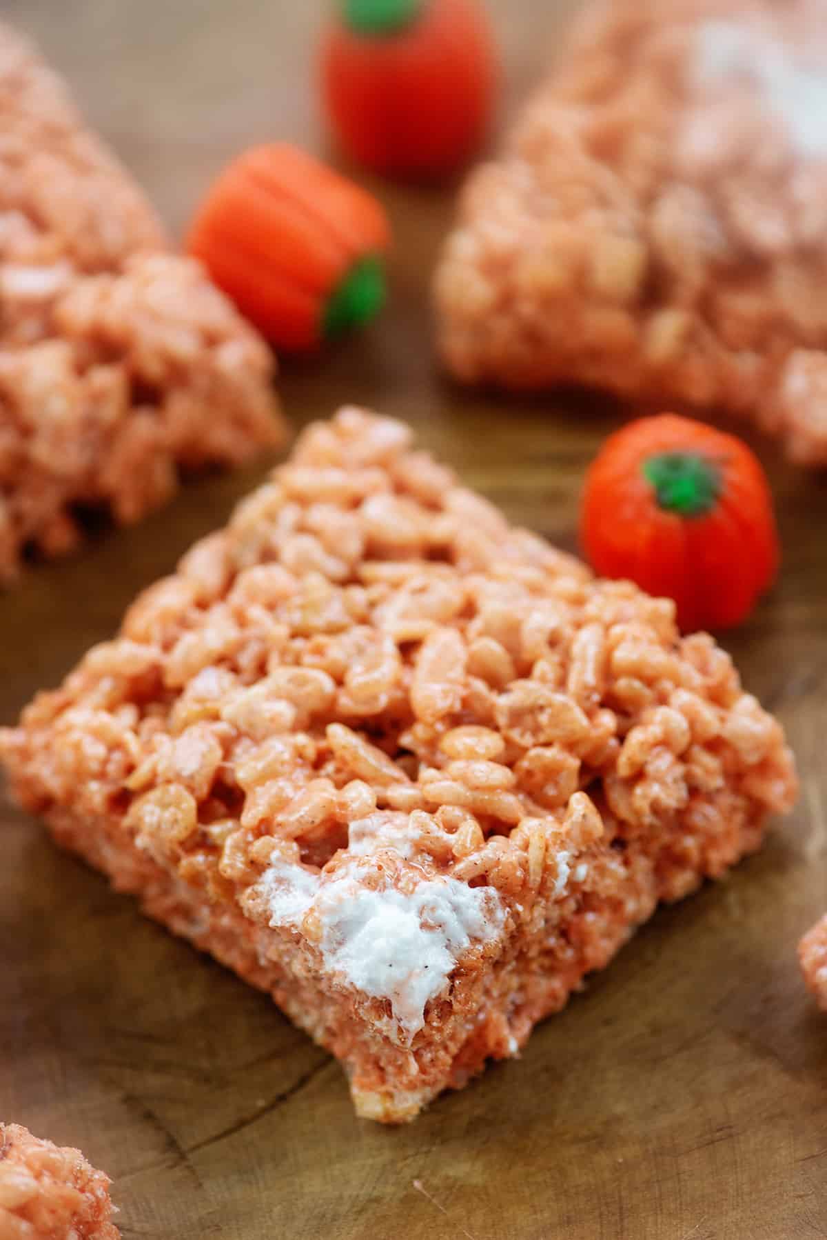 pumpkin spice rice krispies treats on wooden board.