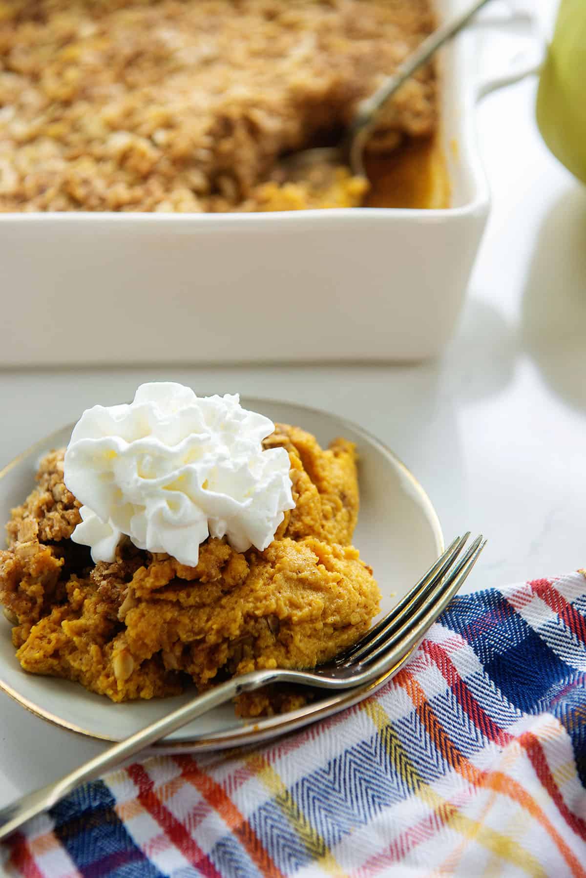 pumpkin crisp on small plate with whipped cream.