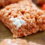 pumpkin rice krispies treat on wooden board.