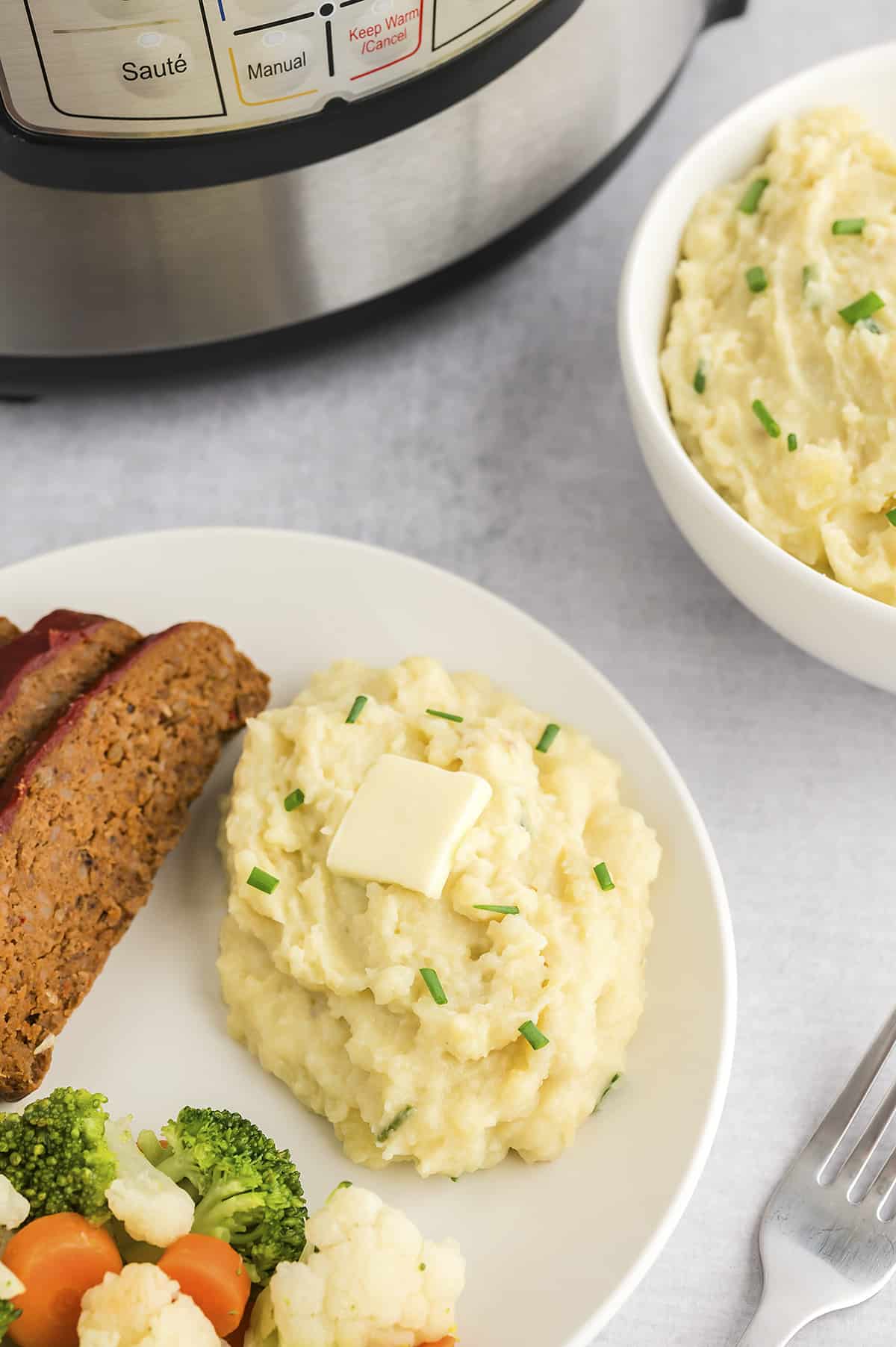 Mashed potatoes, meatloaf, and vegetables on plate.