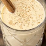 eggnog in glass with cinnamon stick.