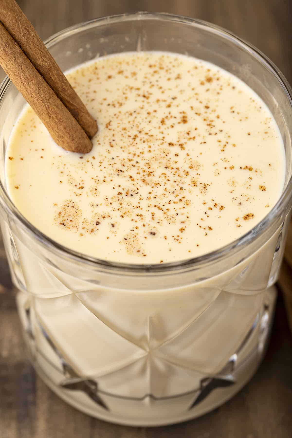 eggnog in glass with cinnamon stick.