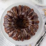 overhead view of a chocolate bundt cake with glaze on cake stand.