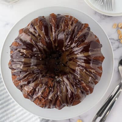 overhead view of a chocolate bundt cake with glaze on cake stand.