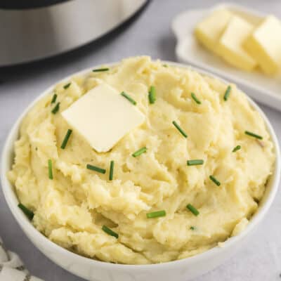 Bowl full of mashed potatoes in front of Instant Pot.