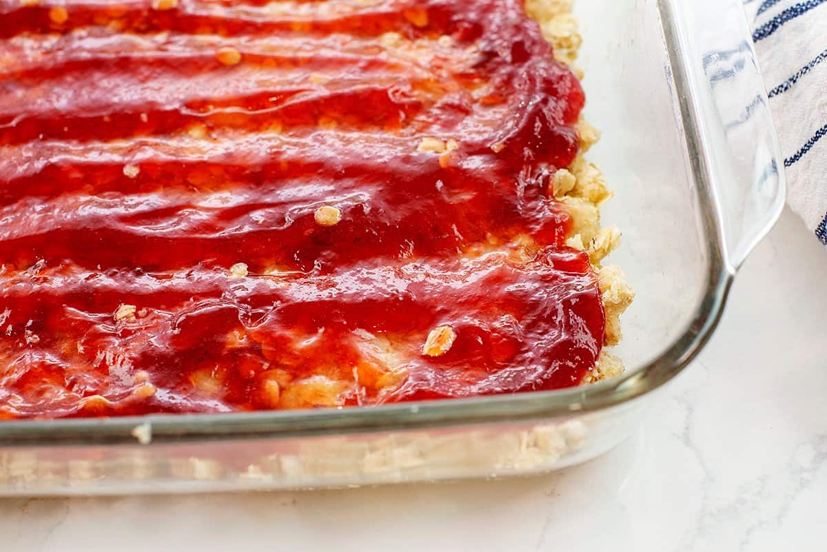 strawberry jam spread over crust.