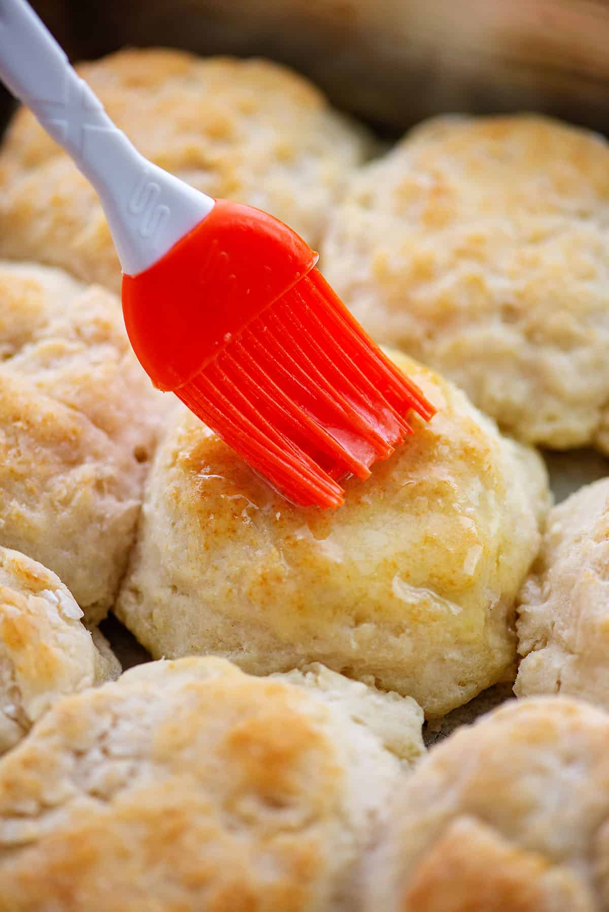 biscuits being brushed with butter.